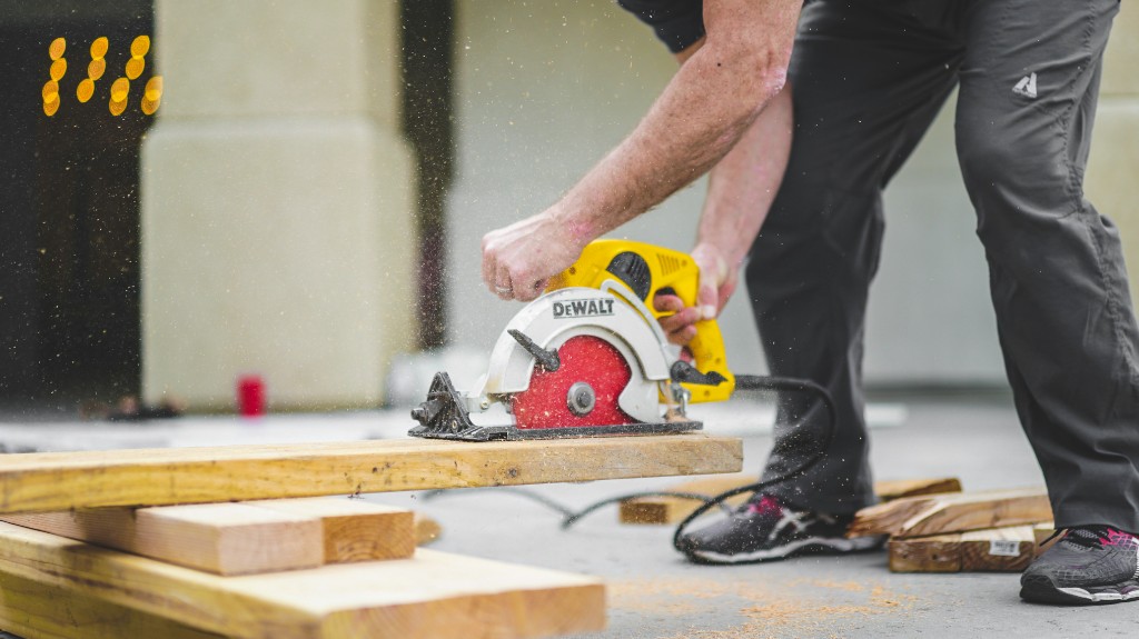 Installer cutting timber boards with a circular saw during flooring preparation